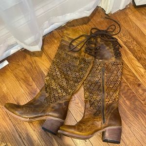 Tan Perforated leather boot  tie behind the knee about couple inches tall heel.